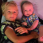 Hunter joined the competition — help win amazing prizes! child, baby, siblings, pillow, bed, smile, cute, cozy, indoor, clothing, boy, infant, portrait, happy, cuddle, dinosaur_print, short_sleeve, casual, lying_down, family