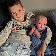 Kimberly Le Moal participe au concours pour gagner de l'argent avec cette photo : child, baby, boy, couch, smile, clothing, hoodie, jeans, socks, shoes, indoor, portrait, family, cute, toddler, sitting, person, cozy, home, blanket