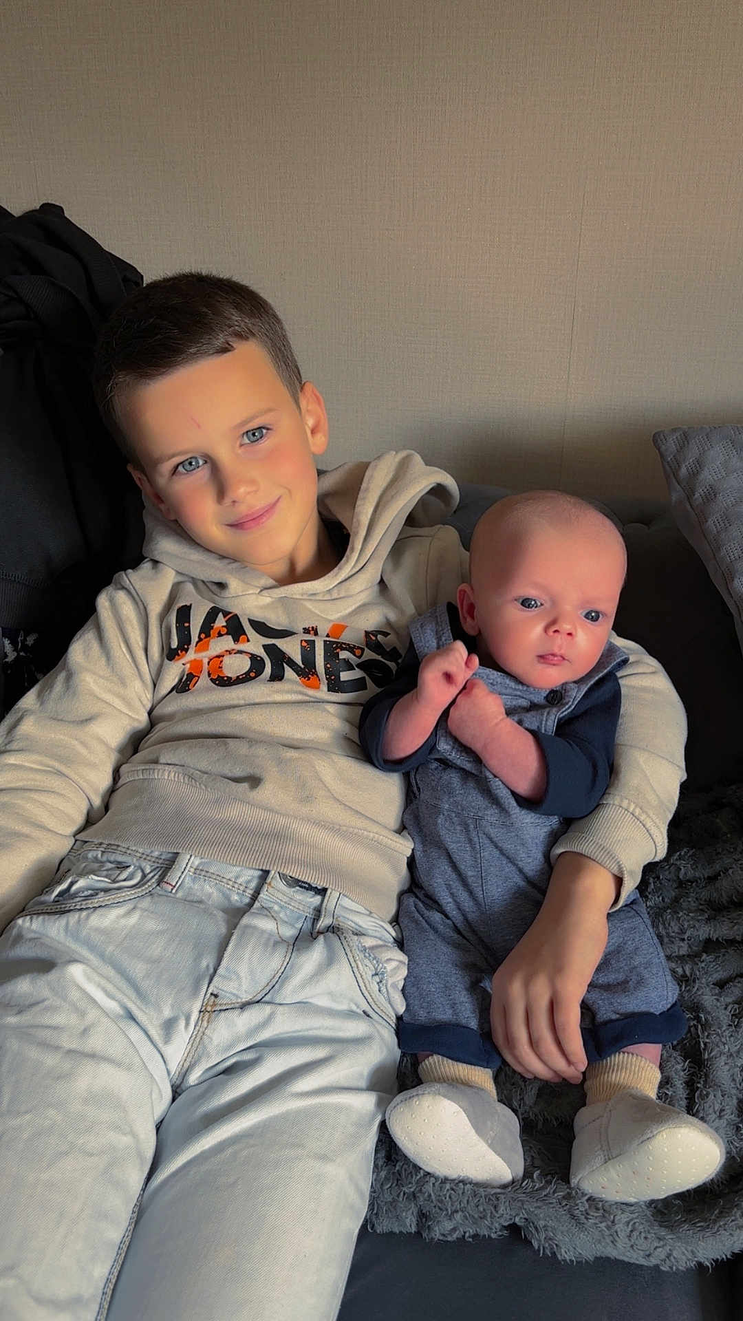 Kimberly Le Moal participe au concours pour gagner de l'argent avec cette photo : child, baby, boy, couch, smile, clothing, hoodie, jeans, socks, shoes, indoor, portrait, family, cute, toddler, sitting, person, cozy, home, blanket