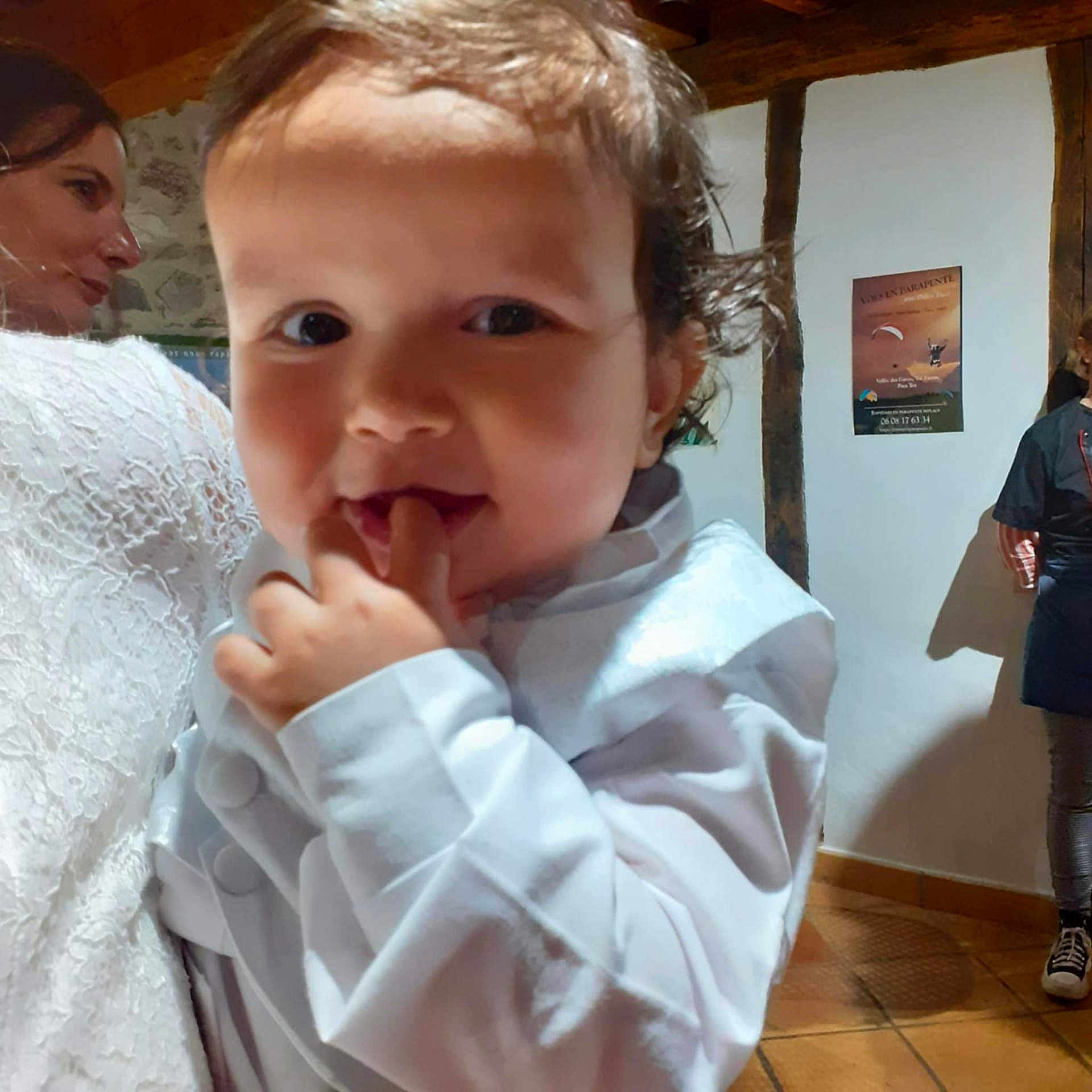 Mathis participe au concours pour gagner de l'argent avec cette photo : toddler, child, person, white_clothing, indoor, portrait, curly_hair, face, hand, woman, lace_dress, background, poster, floor, wooden_beams, smile, fingers, casual, people, light