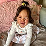 Niomie is registered to the contest to win money with this photo: toddler, child, smiling, happy, indoors, bed, quilt, pillow, blanket, long_sleeve, dress, hair_accessory, cute, playful, portrait, person, young_child, home, cozy, fun