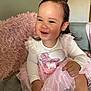Niomie is registered to the contest to win money with this photo: toddler, child, smiling, girl, pink_tutu, long_sleeve_shirt, hair_clip, sitting, couch, pillow, cozy, indoor, happy, cute, sparkly, clothing, portrait, baby, fun, room