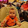 baby, child, high_chair, orange_shirt, person, elderly_person, water_bottle, glasses, indoor, living_room, curtains, lamp, walker, furniture, table, vase, flowers, seated, expression, reaching_hand