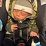 baby, sleeping, car_seat, hoodie, hat, nike, pacifier, socks, clothing, child, infant, straps, safety, cute, peaceful, resting, indoor, seat, black, camouflage
