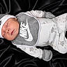 baby, newborn, sleeping, nike, clothing, hat, mittens, onesie, footed_pajamas, bibs, black_background, soft_texture, cute, infant, portrait, cozy, peaceful, child, apparel, sleep