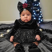 Anastasia is registered to the contest to win money with this photo: baby, child, black_dress, headband, red_rose, snowflake, christmas_tree, holiday, decorations, indoor, blanket, sitting, portrait, cute, face, shoes, black_shoes, toddler, festive, soft_lighting