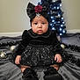 baby, child, black_dress, headband, red_rose, snowflake, christmas_tree, holiday, decorations, indoor, blanket, sitting, portrait, cute, face, shoes, black_shoes, toddler, festive, soft_lighting