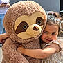 affection, casual_clothing, child, cute, dress, friendship, hair_tied, happy, hugging, outdoor, person, playful, plush_toy, sloth, smartphone, smiling, striped_clothing, sunlight, toy, woman