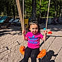 black_leggings, child, clothing, fun, outdoor, person, pink_shirt, playground, playing, recreation, rope, sand, smiling, sneakers, summer, sunlight, swing, toddler, trees, white_socks