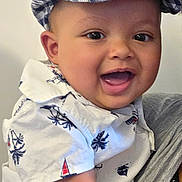 Enoch joined the competition — help win amazing prizes! baby, child, smiling, cap, hat, shirt, patterned_clothing, indoor, person, face, happy, cute, portrait, infant, closeup, cheerful, apparel, holding, arm, skin