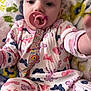 baby, pacifier, pajamas, butterflies, blanket, infant, child, face, hand, clothing, pattern, soft, cute, reaching, lying_down, colorful, fabric, comfort, indoors, portrait