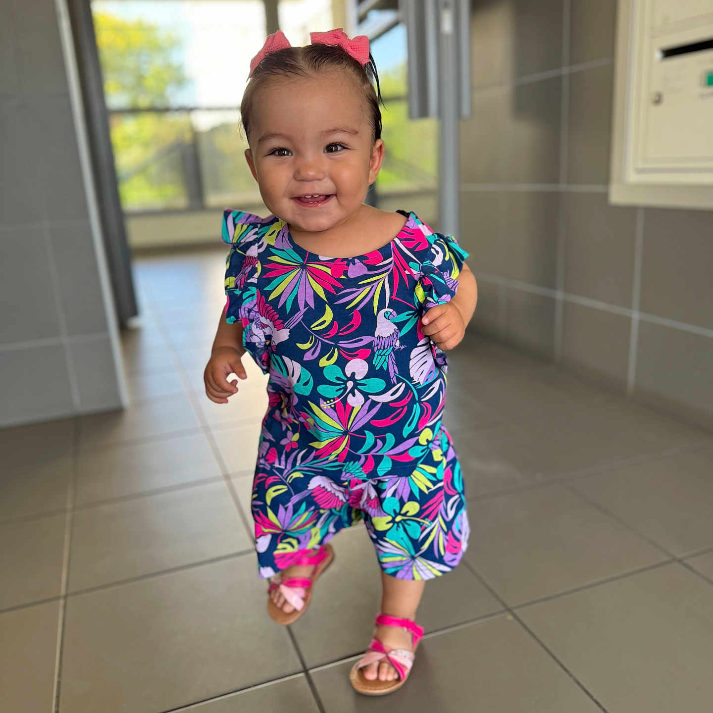 Yusra participe au concours pour gagner de l'argent avec cette photo : baby, bright_colors, child, colorful_clothing, cute, daylight, fashion, floor_tiles, hair_bows, hallway, happy, indoors, person, pink_sandals, portrait, smile, tile_floor, toddler, walking, young_child