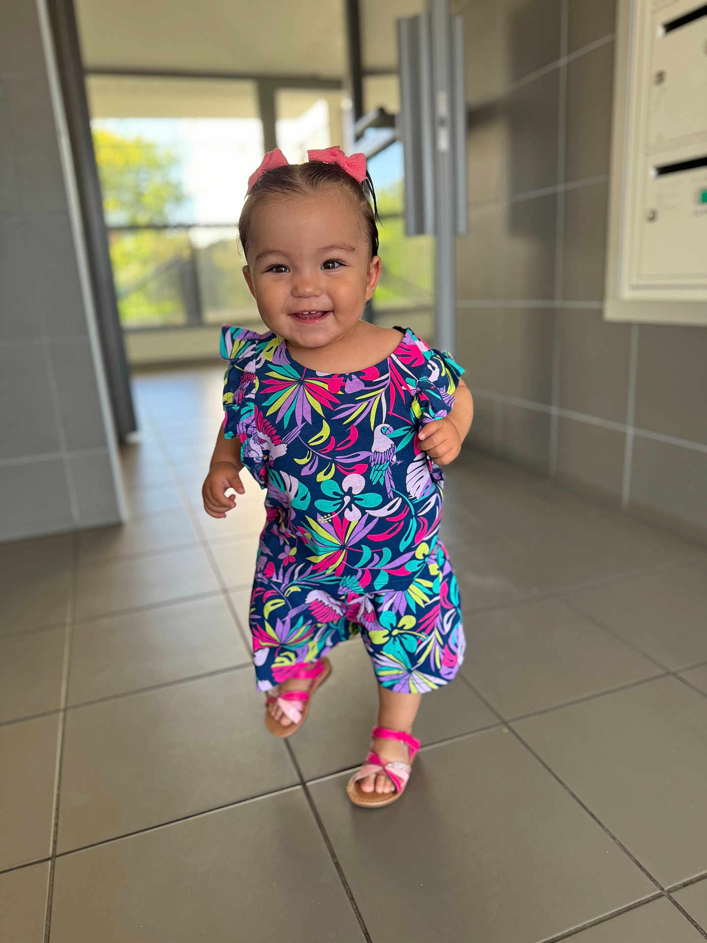 Yusra participe au concours pour gagner de l'argent avec cette photo : toddler, child, smile, indoors, tile_floor, colorful_clothing, pink_sandals, hair_bows, happy, walking, person, portrait, daylight, hallway, young_child, cute, fashion, floor_tiles, bright_colors, baby