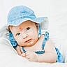 baby, denim_hat, blue_eyes, infant, cute, portrait, white_background, soft_cushion, clothing, baby_girl, child, smile, skin, face, headwear, indoor, closeup, baby_fashion, baby_outfit, baby_skin