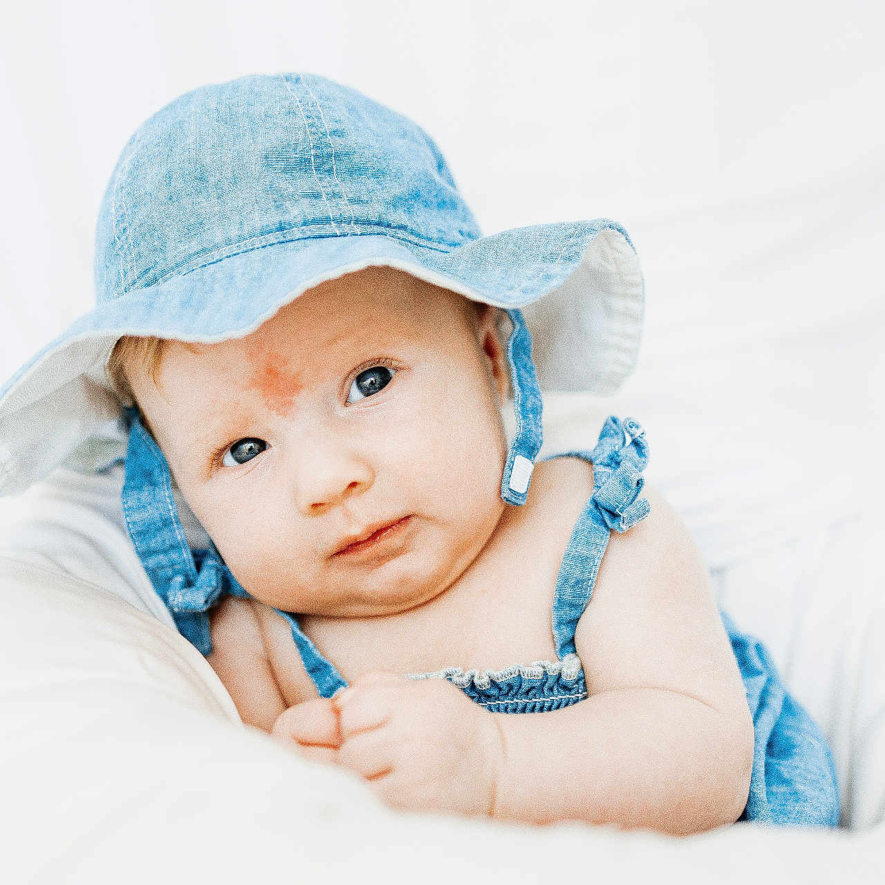 Harleigh joined the competition — help win amazing prizes! baby, denim_hat, blue_eyes, infant, cute, portrait, white_background, soft_cushion, clothing, baby_girl, child, smile, skin, face, headwear, indoor, closeup, baby_fashion, baby_outfit, baby_skin