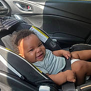 Seven joined the competition — help win amazing prizes! baby, child, infant, smiling, happy, car_seat, car, vehicle, interior, sitting, portrait, face, head, hair, striped_shirt, diaper, seatbelt, sunlight, outdoor, road_trip