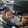 baby, child, infant, smiling, happy, car_seat, car, vehicle, interior, sitting, portrait, face, head, hair, striped_shirt, diaper, seatbelt, sunlight, outdoor, road_trip