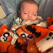 Holden joined the competition — help win amazing prizes! baby, sleeping, blanket, orange, blue, pacifier, skull, bat, infant, cozy, soft, clothing, face, child, cute, resting, indoors, comfort, pattern, portrait