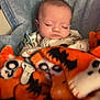 baby, sleeping, blanket, orange, blue, pacifier, skull, bat, infant, cozy, soft, clothing, face, child, cute, resting, indoors, comfort, pattern, portrait