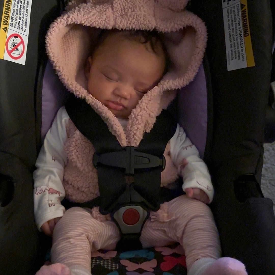 Madilynn joined the competition — help win amazing prizes! baby, bonnet, car, clothing, coat, cushion, face, furniture, hat, head, homedecor, jacket, knitwear, newborn, person, photography, portrait, sleeping, transportation, vehicle