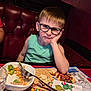 Lorenzo participe au concours pour gagner de l'argent avec cette photo : boy, casual_clothing, child, curly_hair, cute, dining, expression, face, food, fork, glasses, indoor, meal, placemat, plate, red_booth, restaurant, salad, seated, table