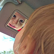 Alessio a rejoint le concours — aidez-le/la à gagner de superbes lots ! blond_hair, blue_sky, car, car_visor, child, closeup, cute, daylight, face, greenery, happy, head, light, mirror, portrait, reflection, smile, vehicle_interior, window, young_child
