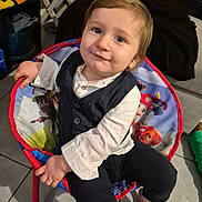 Alessio participe au concours pour gagner de l'argent avec cette photo : toddler, child, boy, chair, indoor, smile, face, clothing, vest, shirt, barefoot, floor, cartoon, toy, hand, blue_eyes, hair, furniture, cute, portrait