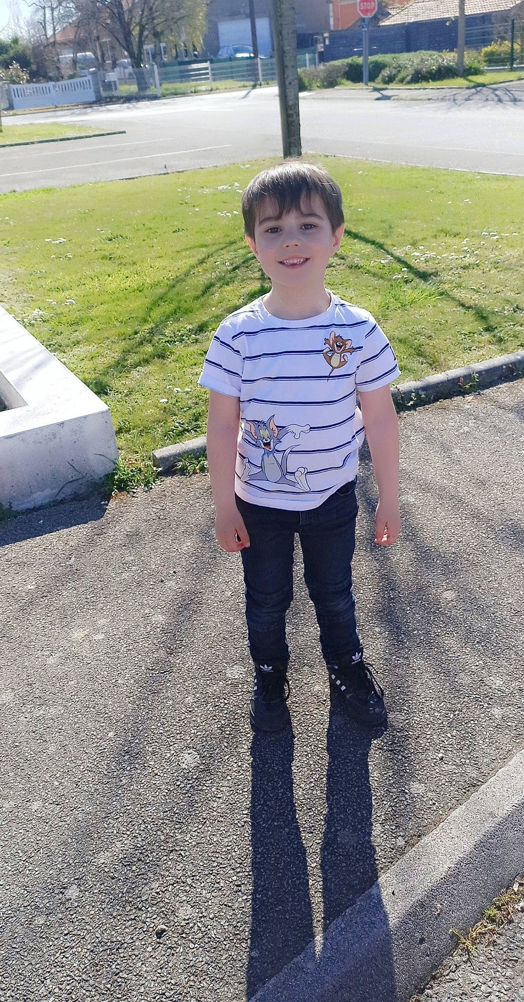 Gabin participe au concours pour gagner de l'argent avec cette photo : asphalt, child, denim, electric_blue, eye, fun, grass, happy, joy, pattern, pedestrian, person, road, road_surface, shadow, sleeve, smile, t_shirt, toddler, tree