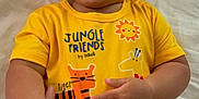 Gael is registered to the contest to win money with this photo: baby, child, infant, smiling, yellow_clothing, jungle_theme, tiger, giraffe, elephant, crocodile, zebra, hand, happy, lying_down, cute, skin, face, short_hair, indoors, white_background