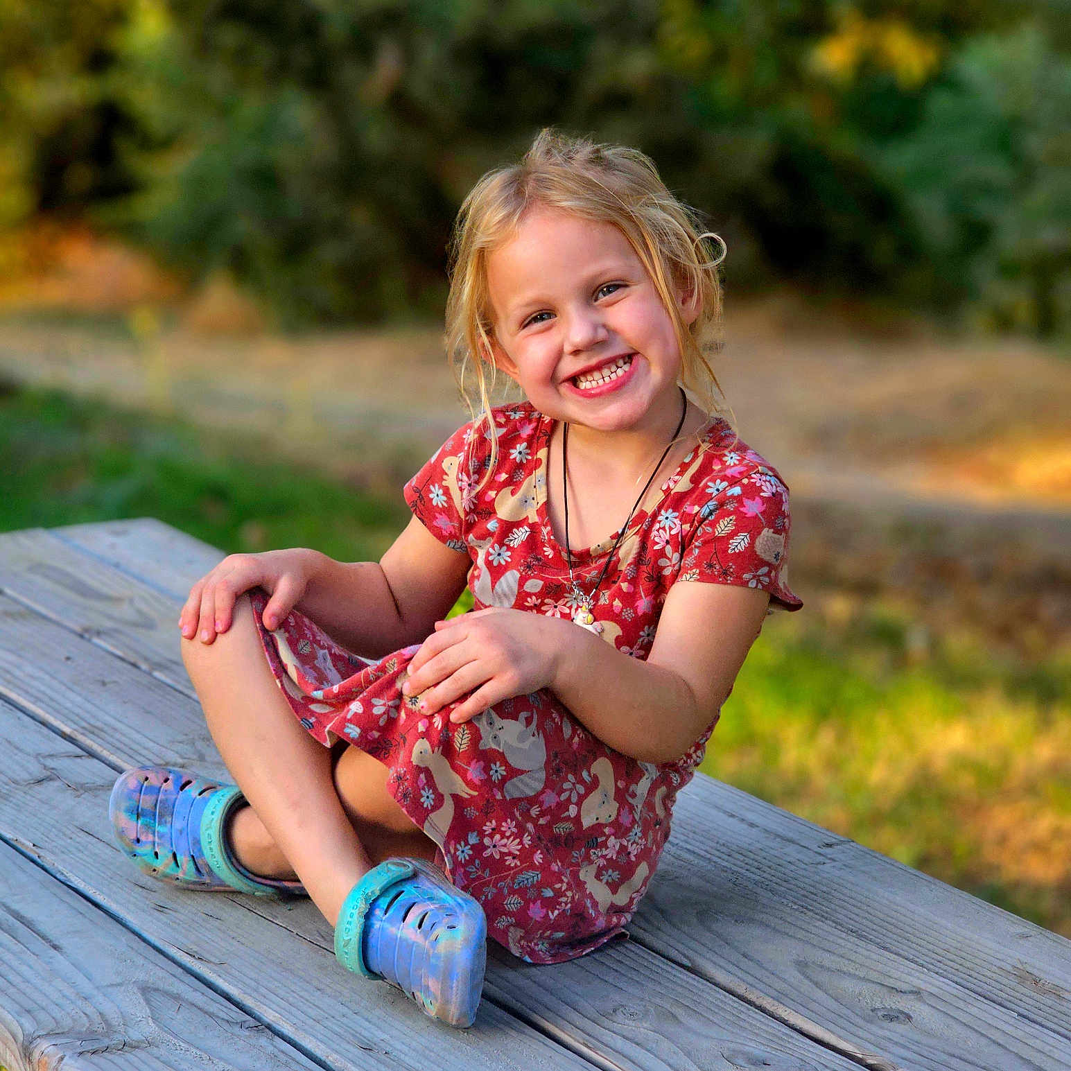 Emilee joined the competition — help win amazing prizes! blonde, child, clothing, face, female, footwear, girl, grass, hair, happy, head, pants, person, photography, plant, portrait, shoe, sitting, smile, wood