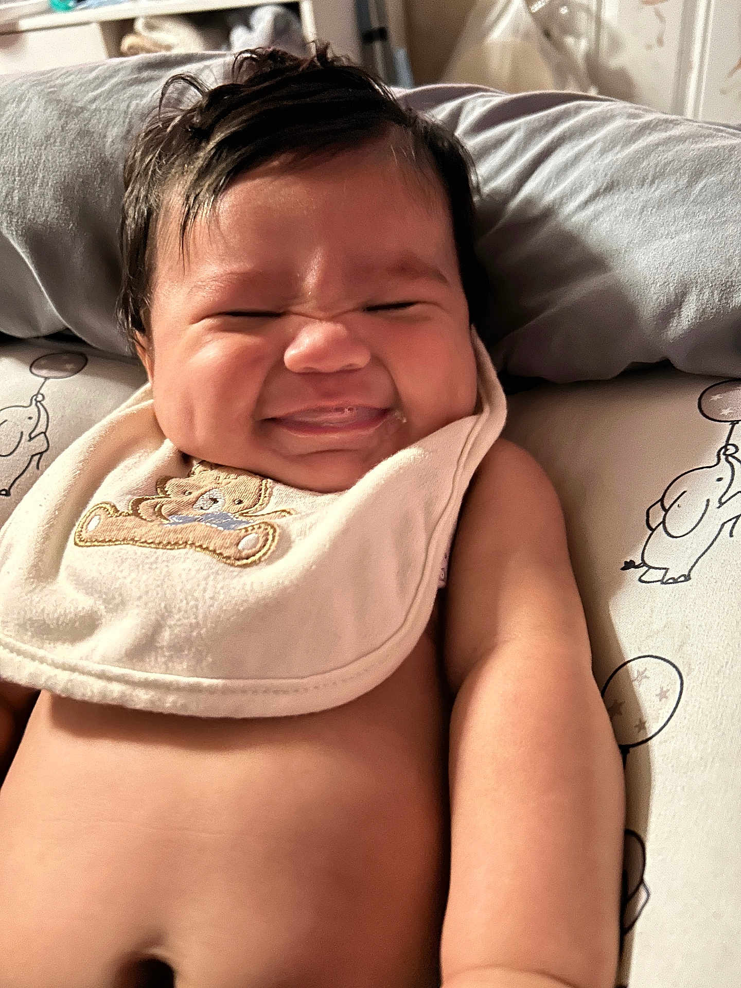 Ezereth is registered to the contest to win money with this photo: baby, infant, smile, face, bib, teddy_bear, pillow, elephant, cute, chubby, skin, arm, lying_down, indoors, expression, child, person, closeup, adorable, happy