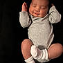 Ezereth is registered to the contest to win money with this photo: baby, infant, sleeping, smiling, onesie, socks, arm, face, closed_eyes, peaceful, soft_skin, newborn, cute, portrait, lying_down, dark_background, cozy, small_hands, relaxed, child