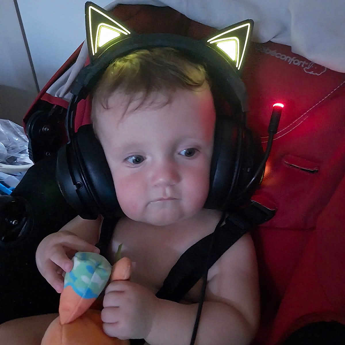 Darko a rejoint le concours — aidez-le/la à gagner de superbes lots ! baby, baby_toy, cat_ears, child, chubby_cheeks, cute, expressionless, face, head, headphones, indoor, infant, person, plush_toy, red, seatbelt, soft_toy, stroller, toddler, toy