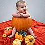 Bowie is registered to the contest to win money with this photo: baby, pumpkin, orange, blanket, cute, smiling, child, fall, autumn, holiday, decor, small_pumpkins, happy, sitting, indoors, portrait, seasonal, festive, skin, head