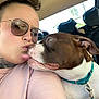 Pebbles is registered to the contest to win money with this photo: person, dog, selfie, tattoo, sunglasses, car_interior, collar, pet, affection, licking, cute, closeup, casual, human_dog_interaction, brown_dog, white_dog, friendship, happy, love, seat