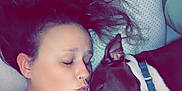 Pebbles is registered to the contest to win money with this photo: woman, dog, sleeping, couch, pillow, tattoo, necklace, black_clothing, indoor, closeup, pet, affection, snuggling, relaxing, face, hair, collar, toy, resting, companion
