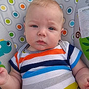 Evan is registered to the contest to win money with this photo: baby, infant, child, striped_clothing, colorful, pattern, baby_seat, face, expression, serious, blue_eyes, arm, hand, cute, portrait, indoors, closeup, young, person, sitting
