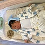 Owen is registered to the contest to win money with this photo: baby, sleeping, bassinet, blanket, clothing, elephant_pattern, infant, newborn, person, portrait, sleepwear, soft_toys, textile, white_background, blue, cute, cozy, baby_bib, baby_pants, indoors