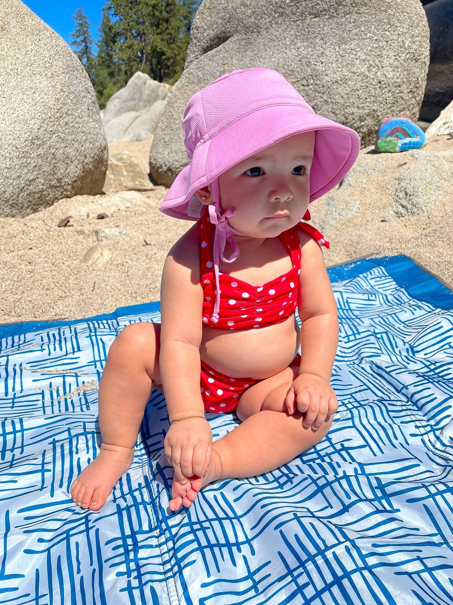Mikayla is registered to the contest to win money with this photo: azure, baby, baby_toddler_clothing, blue, cap, electric_blue, foot, fun, hat, headwear, human_leg, leisure, person, photograph, pink, recreation, sand, summer, sun_hat, thigh