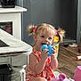 toddler, child, toy, indoor, floor, pink, hair_ties, blue_toy, smiling, person, furniture, wood_floor, bucket, play, cute, young_child, pigtails, colorful, happy, casual