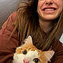 Shanti -Means Peace is registered to the contest to win money with this photo: woman, smile, cat, orange_cat, white_cat, pet, indoor, close_up, happy, face, hair, fur, cute, eyes, nose, casual_clothing, portrait, friendship, animal, human