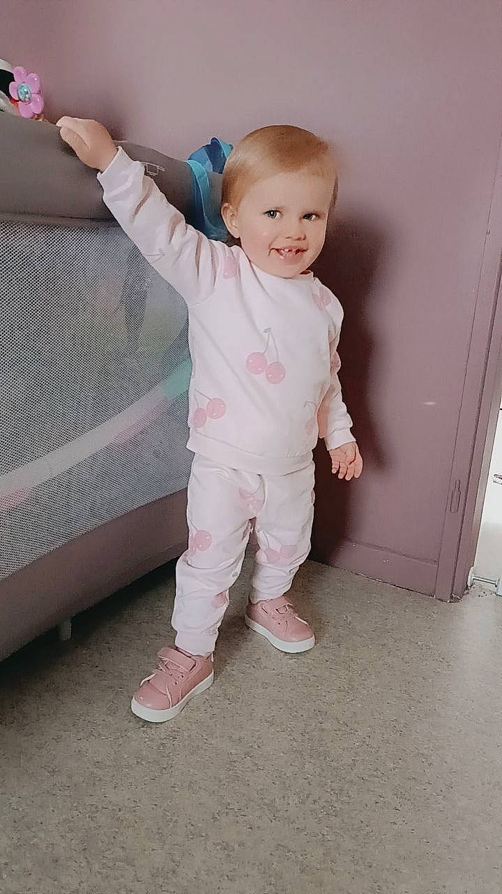 Ambre participe au concours pour gagner de l'argent avec cette photo : baby, baby_toddler_clothing, child, flooring, foot, gesture, happy, human_leg, joy, leg, magenta, pattern, person, pink, portrait_photography, sitting, sleeve, smile, standing, t_shirt