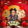 Angel is registered to the contest to win money with this photo: child, toddler, traditional_clothing, fan, braided_hair, bows, red_lanterns, cherry_blossoms, pagoda, decorative_background, calligraphy, gold, red, indoor, portrait, cute, sitting, cultural, festival, celebration