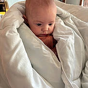 Athena is registered to the contest to win money with this photo: baby, blanket, indoor, child, face, curious, wrapped, cozy, soft, infant, cute, portrait, warm, bedroom, comfort, newborn, expression, head, skin, clothing
