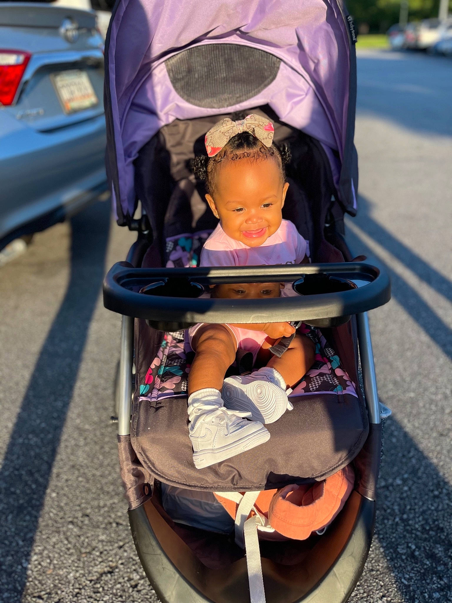 Ava is registered to the contest to win money with this photo: auto_part, automotive_design, automotive_exterior, automotive_lighting, automotive_tire, baby, baby_carriage, comfort, joy, mode_of_transport, motor_vehicle, orange, person, personal_luxury_car, snapshot, tire, toddler, tree, trunk, vehicle_door