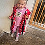 baby_gate, braided_hair, casual, child, concrete_floor, cozy, cute, door, footwear, glass_door, indoor, mickey_mouse, person, pink_clothing, playful, red_robe, smiling, standing, toddler, white_wall