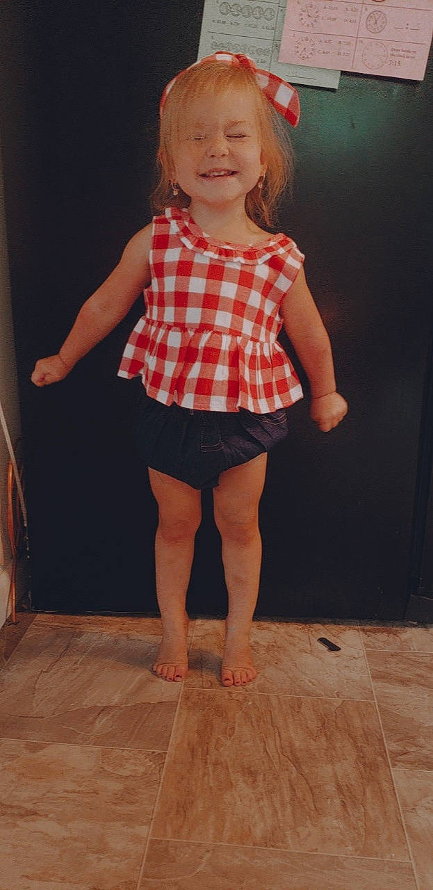 Emberlyn is registered to the contest to win money with this photo: barefoot, child, child_model, clothing, design, dress, joy, leg, pattern, person, plaid, shoulder, sitting, standing, textile, toddler