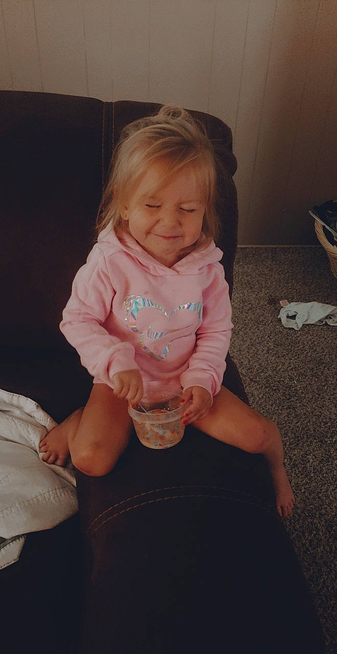 Emberlyn is registered to the contest to win money with this photo: arm, baby, cheek, child, eye, finger, fun, hand, iris, leg, person, pink, play, sitting, skin, smile, thumb, toddler