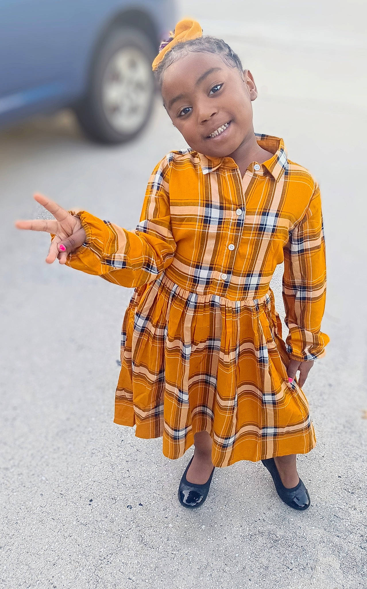Kai joined the competition — help win amazing prizes! automotive_tire, baby_toddler_clothing, car, day_dress, dress, electric_blue, gesture, happy, joy, one_piece_garment, orange, pattern, people, person, plaid, sleeve, smile, tartan, tire, toddler