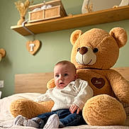 Elyo participe au concours pour gagner de l'argent avec cette photo : baby, teddy_bear, plush_toy, bed, blanket, child, indoor, cozy, soft_toy, cute, home_decor, wooden_shelf, heart_shaped_decor, casual_clothing, jeans, socks, portrait, comfort, love, warm_lighting